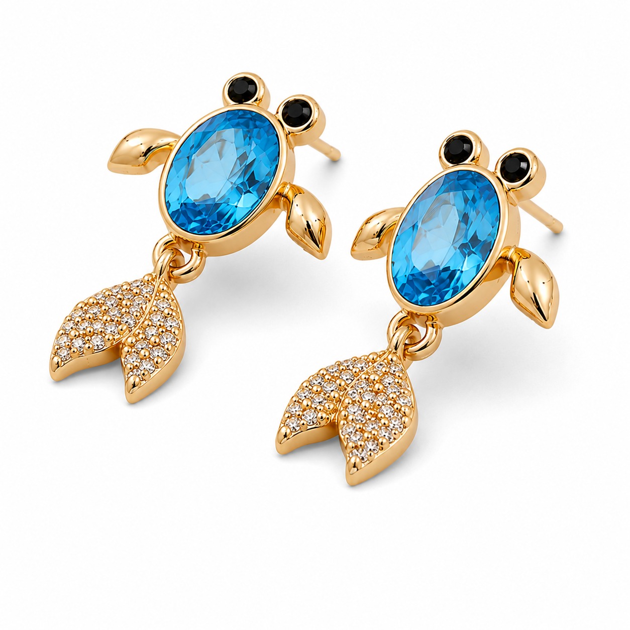 Close-up angle showing the intricate gold-toned aquatic design and sparkling blue and clear crystals of the drop earrings — House of Ruhira