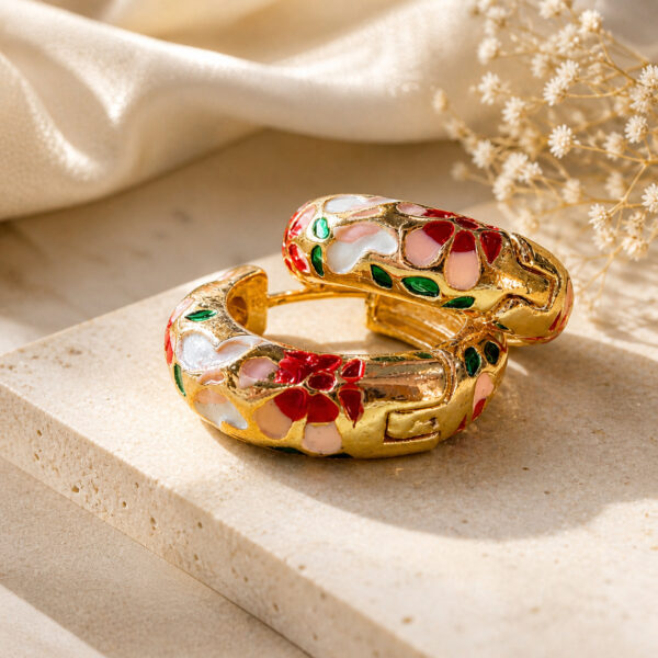Pair of gold-plated enamel hoop earrings with red, pink, white, and green floral design on a clean white studio background — House of Ruhira