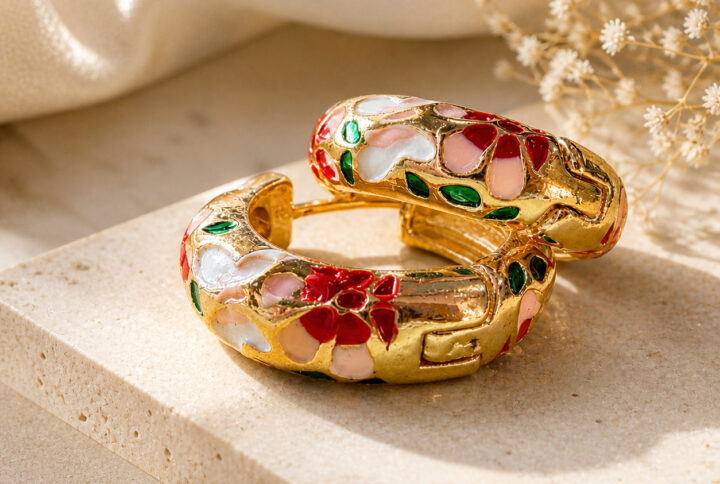 Pair of gold-plated enamel hoop earrings with red, pink, white, and green floral design on a clean white studio background — House of Ruhira