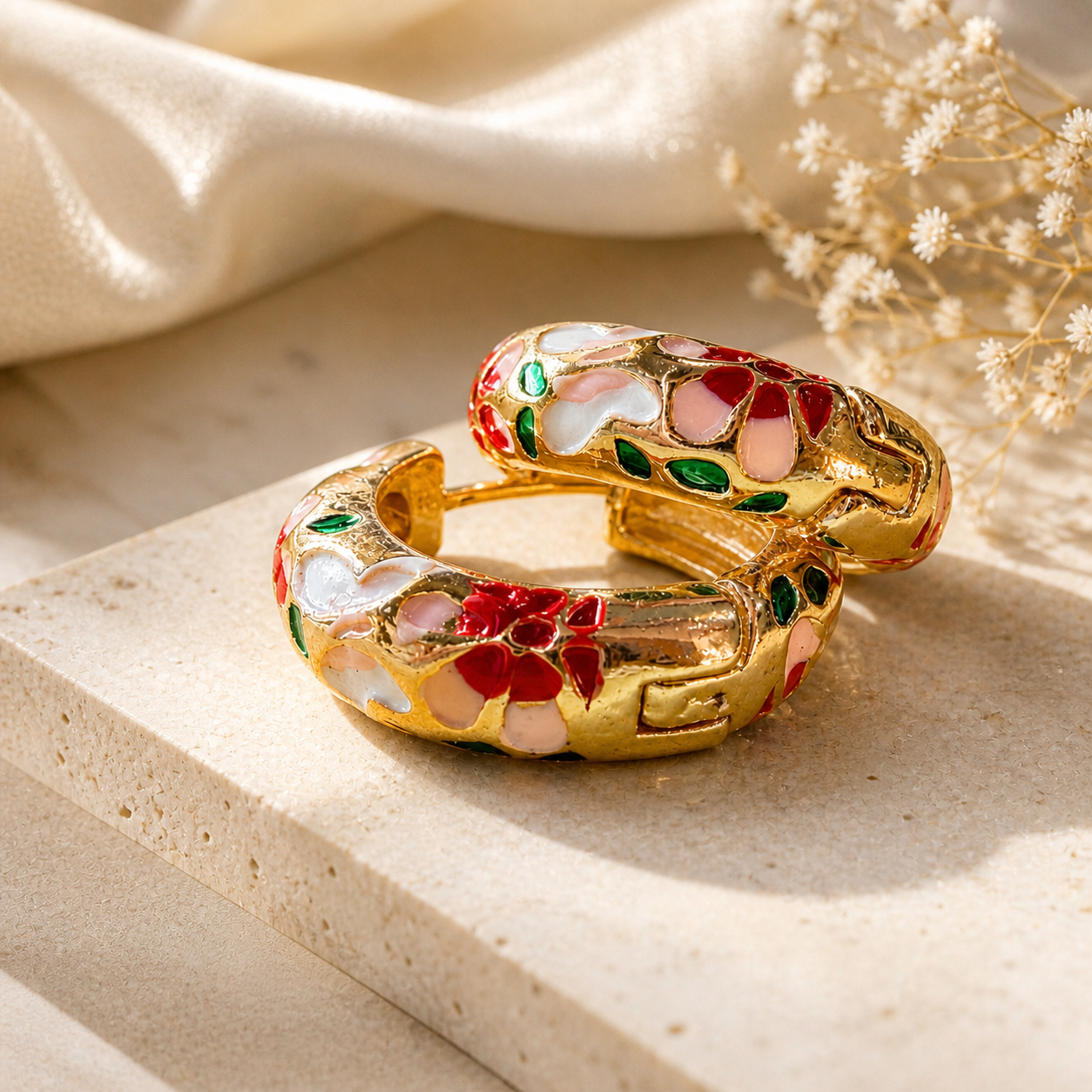Pair of gold-plated enamel hoop earrings with red, pink, white, and green floral design on a clean white studio background — House of Ruhira