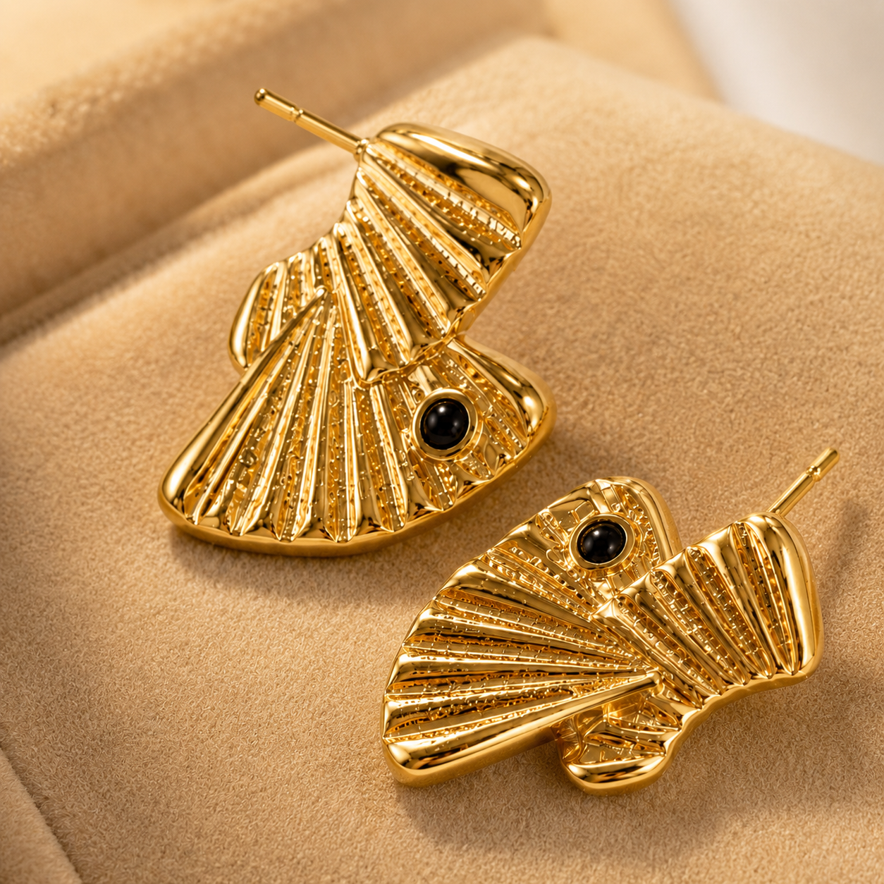 Extreme macro detail of a gold fluted fan stud earring, highlighting the intricate texture and the bezel-set black onyx stone — House of Ruhira