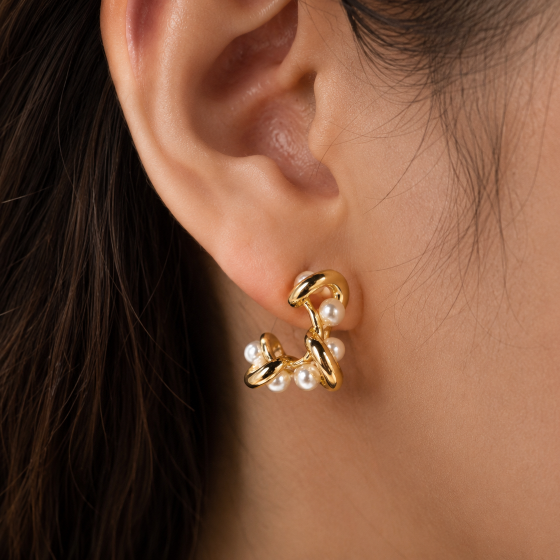 A model wearing the modern gold pearl drop earrings, showcasing their elegant drape and how they frame the face — House of Ruhira