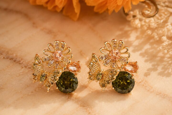 Gold-plated floral and butterfly stud earrings with olive green, peach, and clear cubic zirconia on a clean white studio background — House of Ruhira