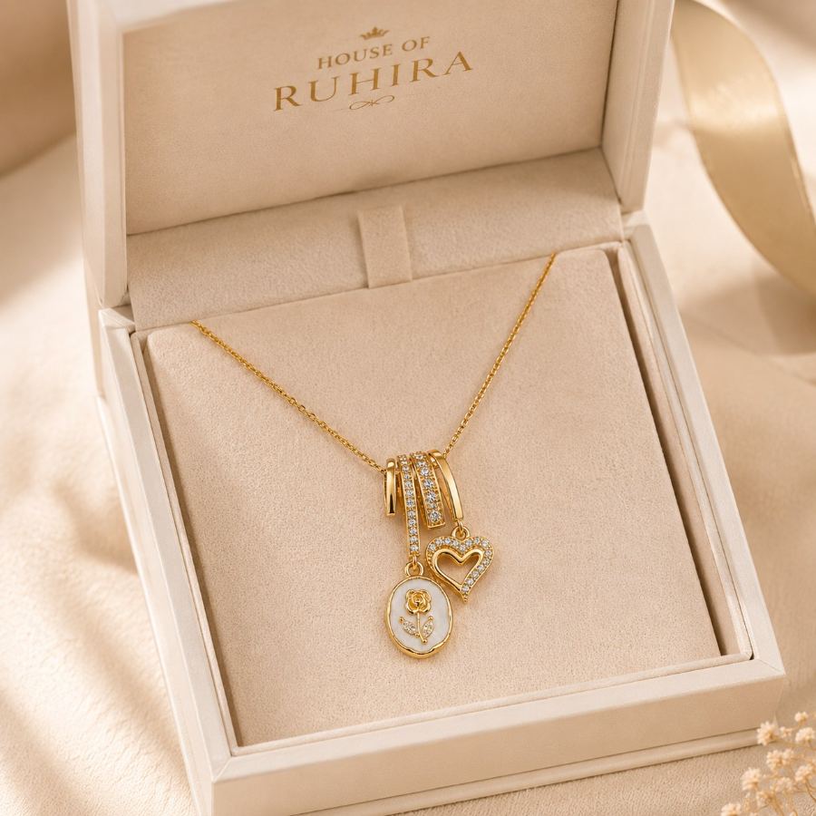Flat lay styling of the gold charm necklace with a small bouquet of dried flowers, a silk scarf, and a handwritten note on a neutral surface – House of Ruhira