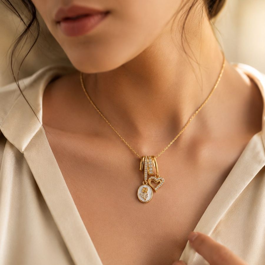 Extreme macro detail of the gold rose motif on the white mother-of-pearl oval charm and the intricate cubic zirconia setting on the heart charm – House of Ruhira