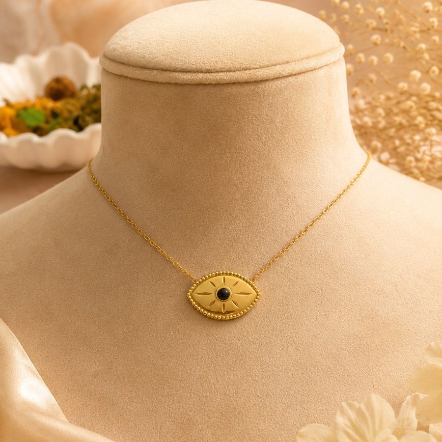 Flat lay styling of the anti-tarnish gold evil eye necklace with a silk scarf and a small journal, creating a chic everyday aesthetic – House of Ruhira