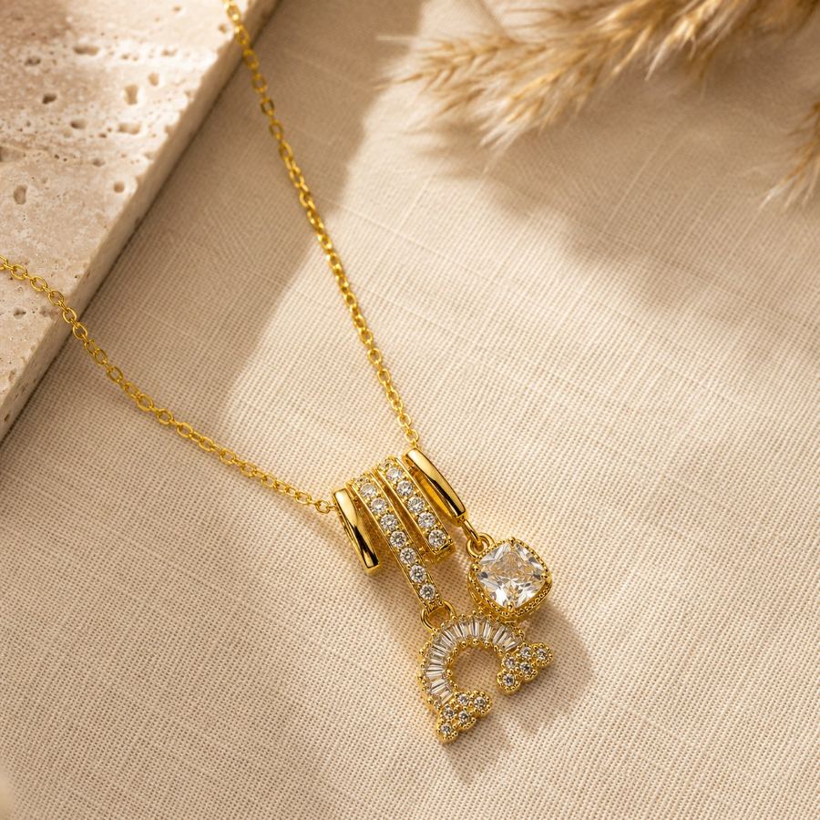 flat lay styling of gold charm necklace with minimalist fashion accessories and a silk scarf – House of Ruhira