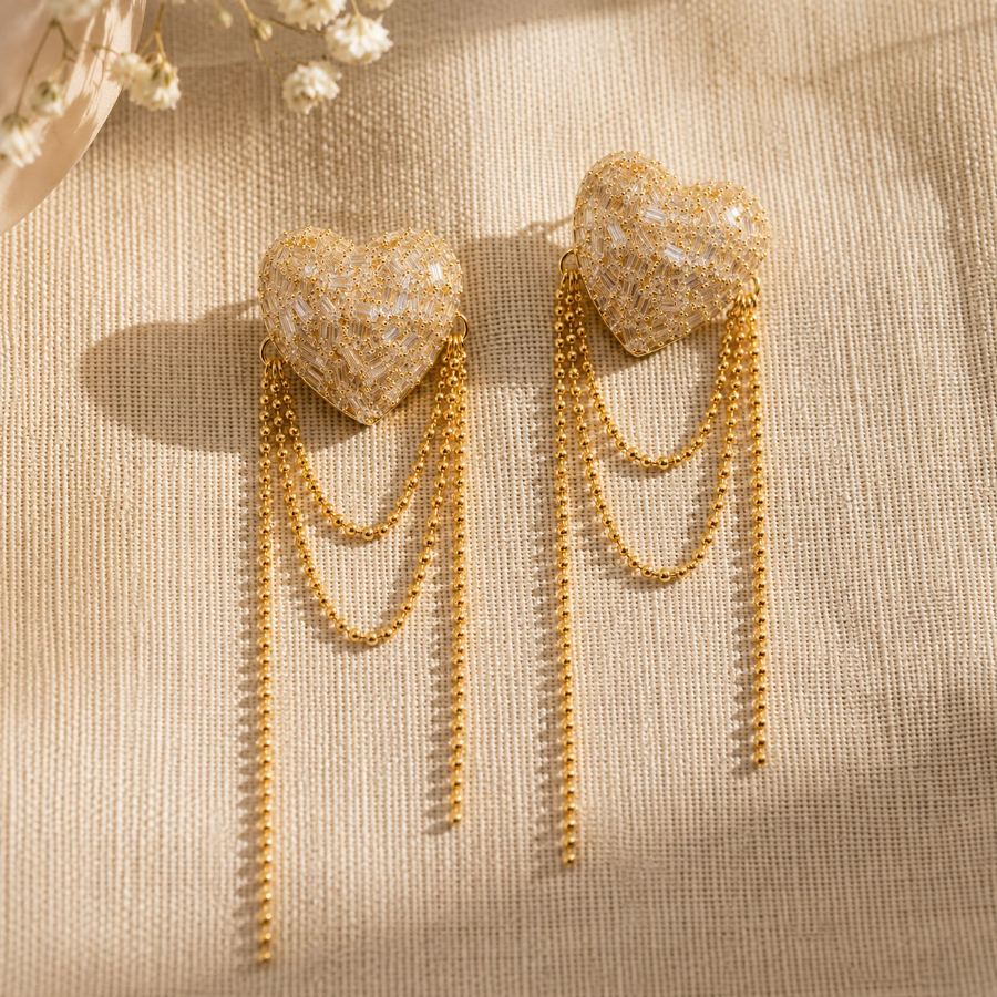 Extreme macro detail of baguette and round crystals pavé-set on the heart motif of gold drop earrings – House of Ruhira