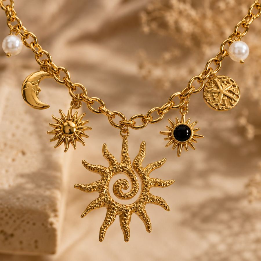 gold charm necklace styled in a flat lay with small dried flowers and a golden ribbon on a soft fabric – House of Ruhira