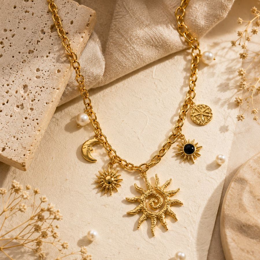 extreme macro detail of the textured gold sun charm and small pearl on the celestial necklace – House of Ruhira
