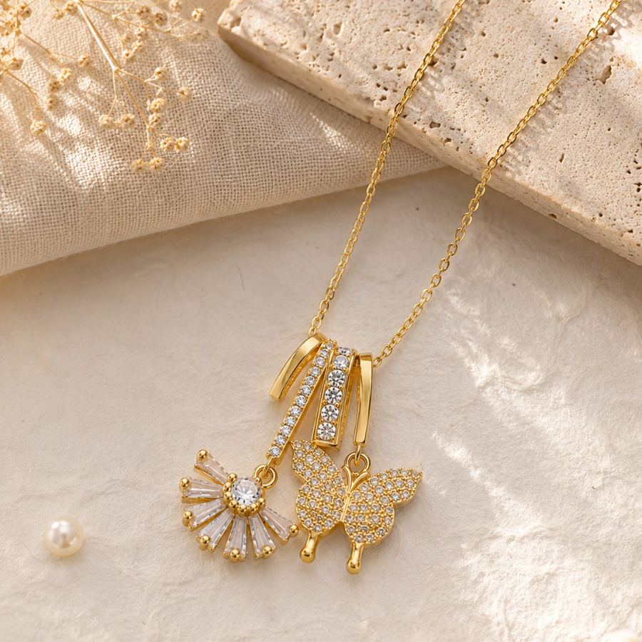 Extreme macro detail of the cubic zirconia pave setting on the butterfly and fan pendants of the gold charm necklace – House of Ruhira