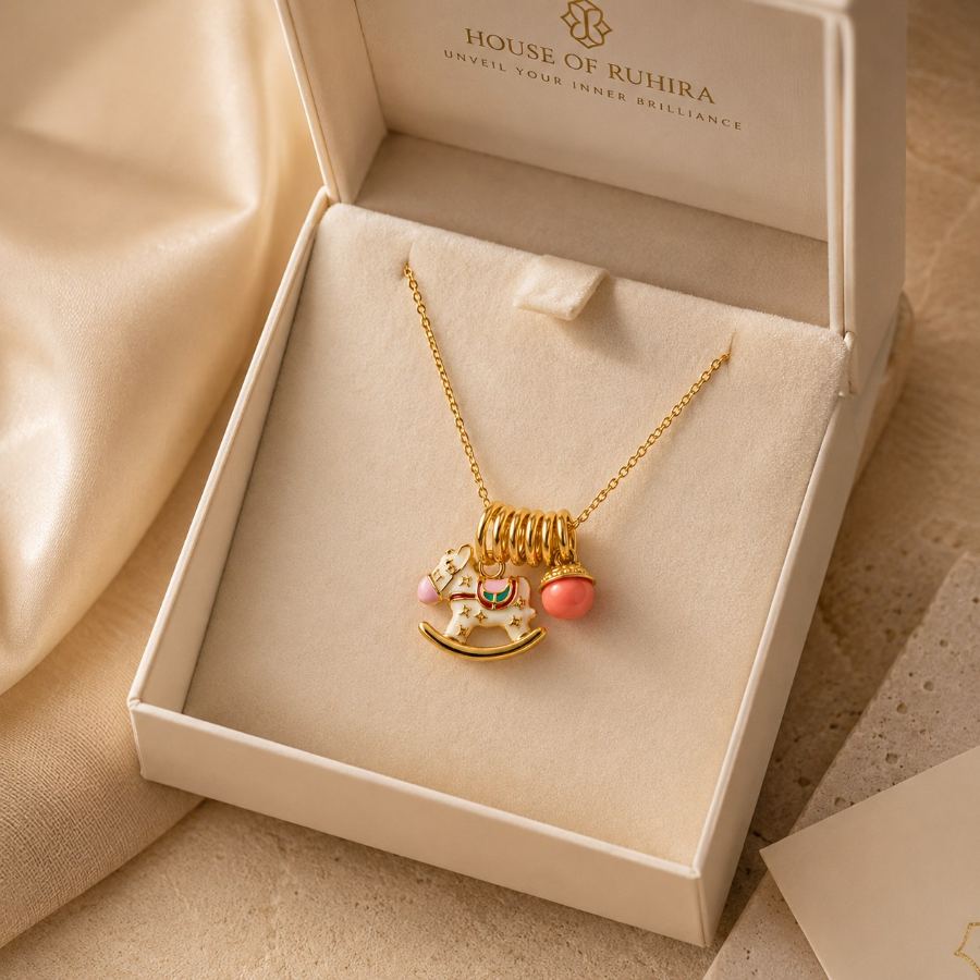 Extreme macro detail of the white enamel rocking horse charm with gold stars and pink accents on a gold-plated necklace – House of Ruhira